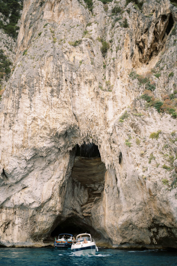 Cliff and cave with two boats in front, in the Amalfi Coast.