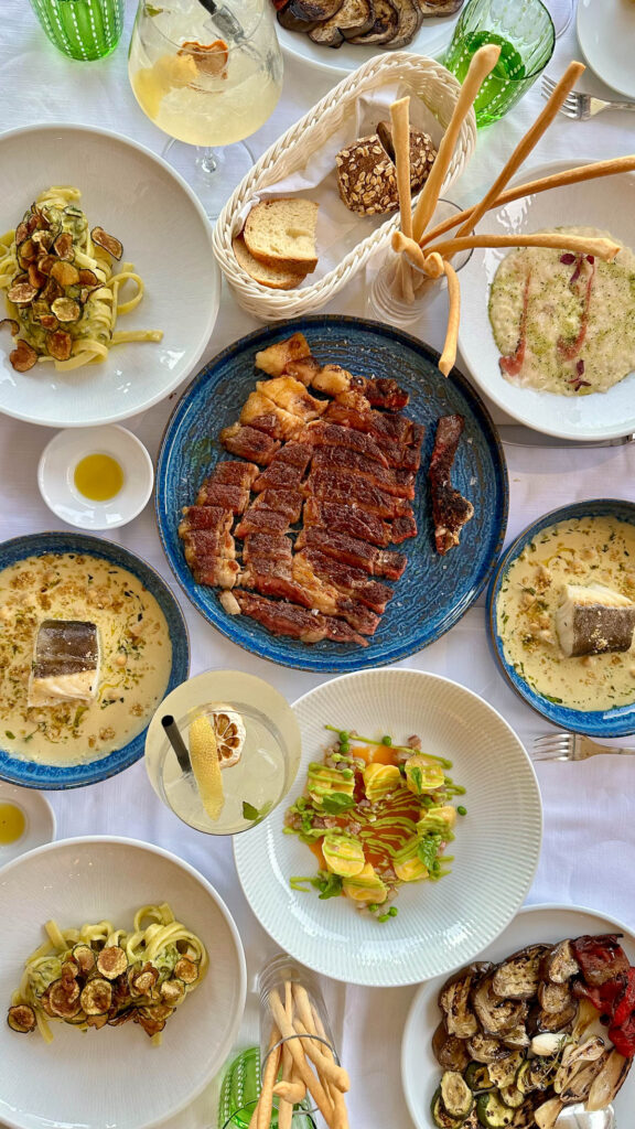 Plates of gourmet food on a table at L'Antica Cartiera restaurant at Hotel Marmorata.