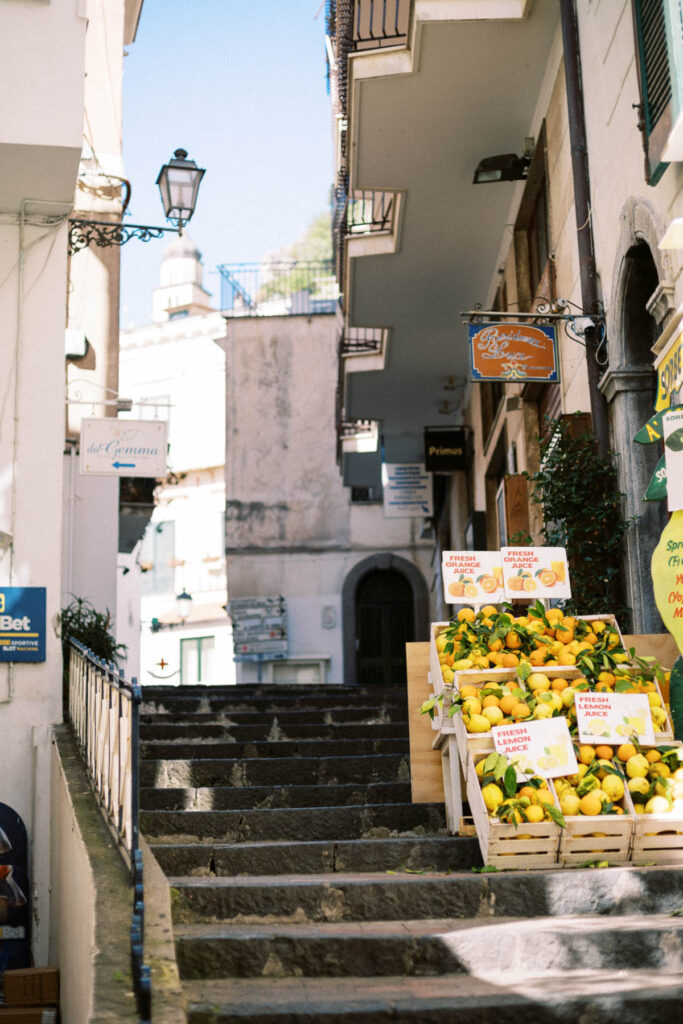 Steps in Amalfi town with baskets of lemons for sale.