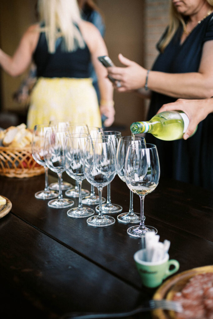 wine being poured into glasses at a vineyard in Italy
