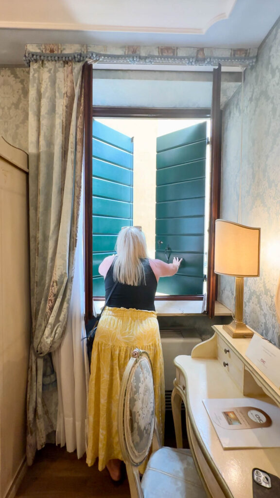 a woman opening hotel window in Venice