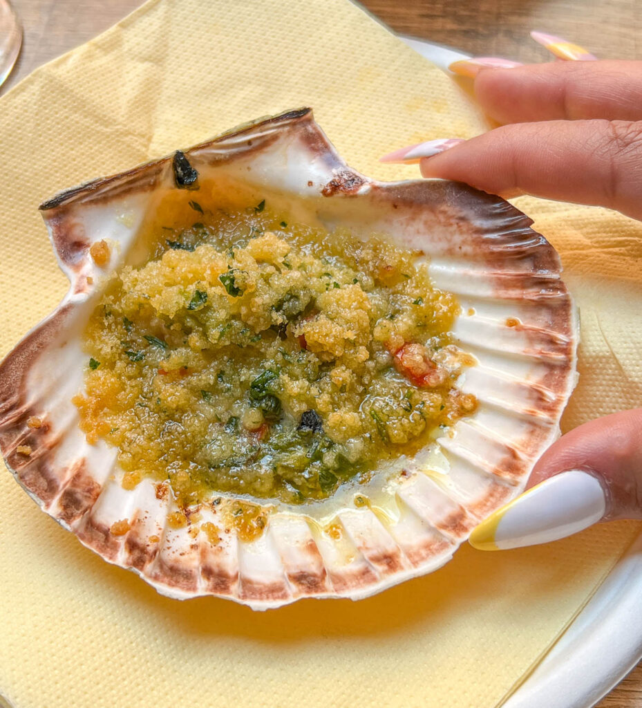 close up of scallop shell with toppings