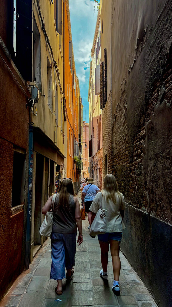 woman walking through a narrow alley venice