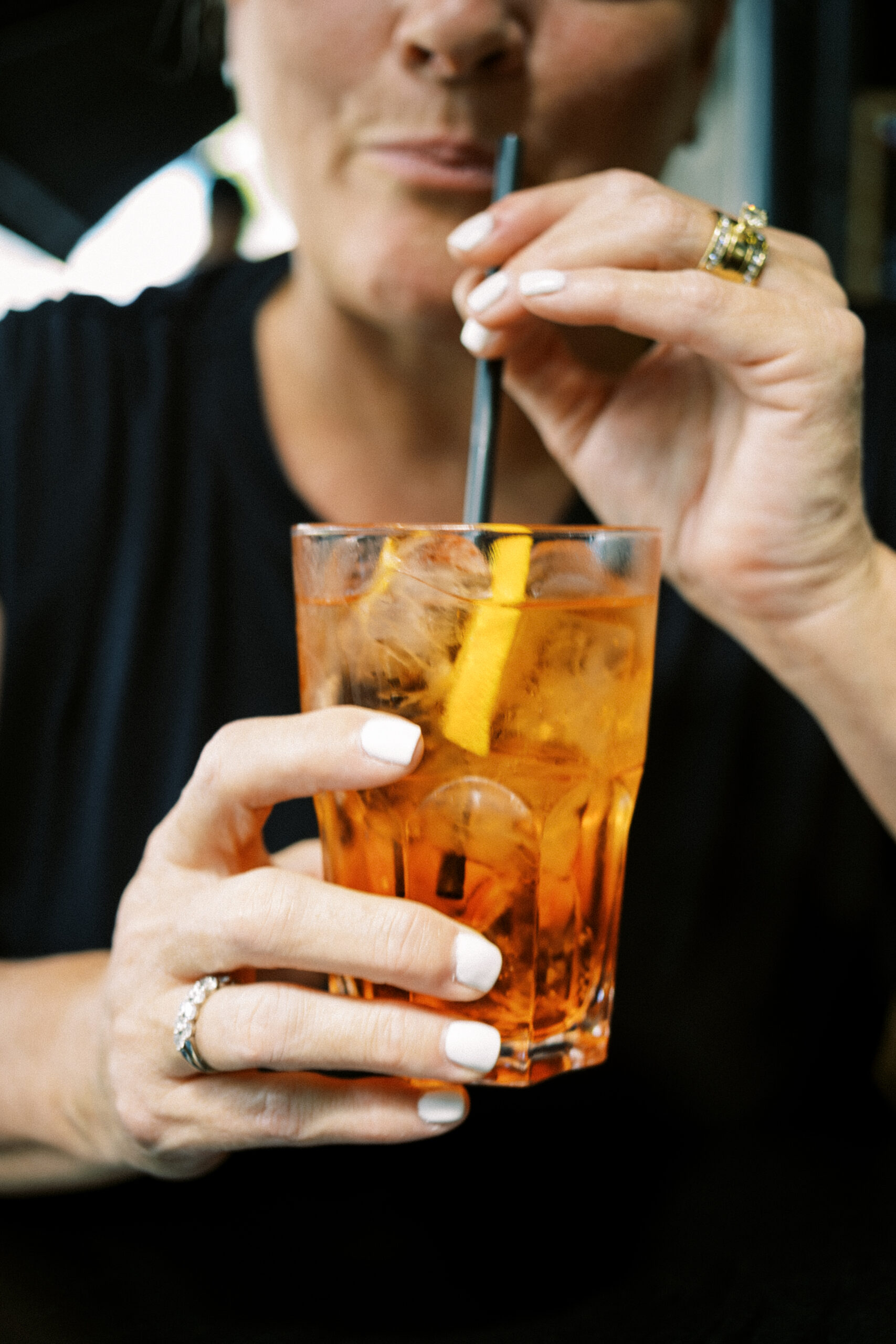 a woman drinking an Aperol spritz