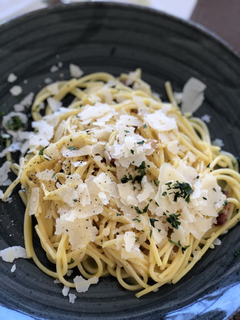 a plate of fresh pasta with parmesan cheese on top