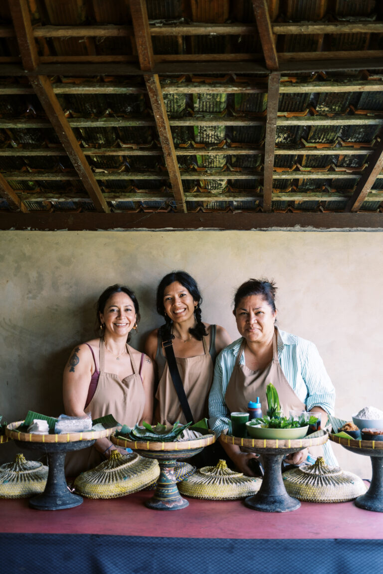 Liz, Toni and Cynthia in aprons behind a table of ingredients at a cooking class in Bali