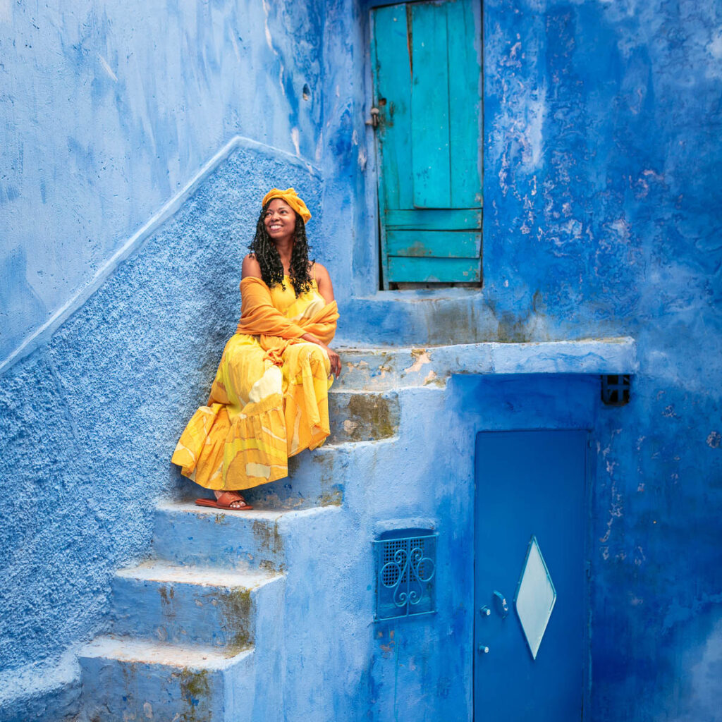 woman in yellow seated on blue stairs