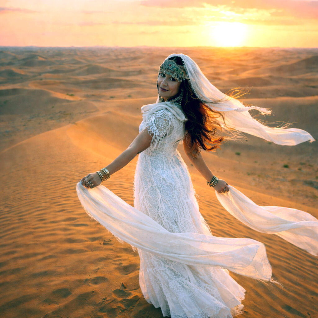 woman in lace dress standing on a sand dune