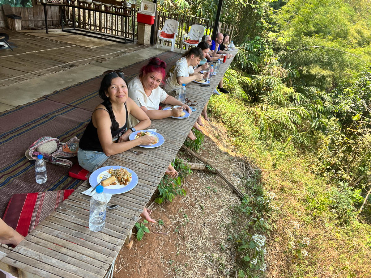 Travelers sitting down to a meal outdoors in Thailand