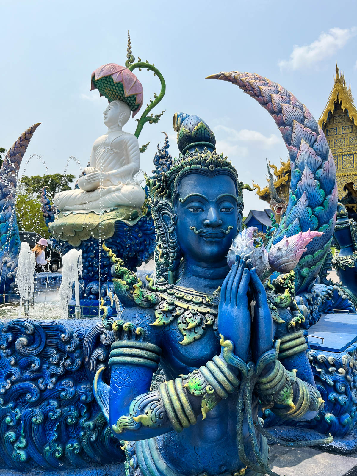 A blue guardian statue at a temple in Thailand