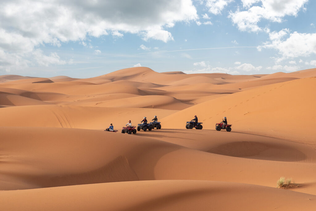 Quad runners driving off-road in the Erg Chebbi desert near Merzouga, Morocco