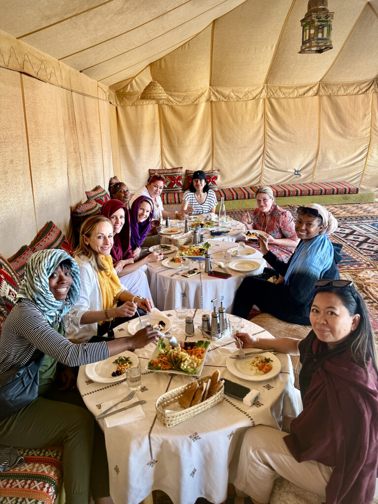 Women inside a nomad tent eating a meal.