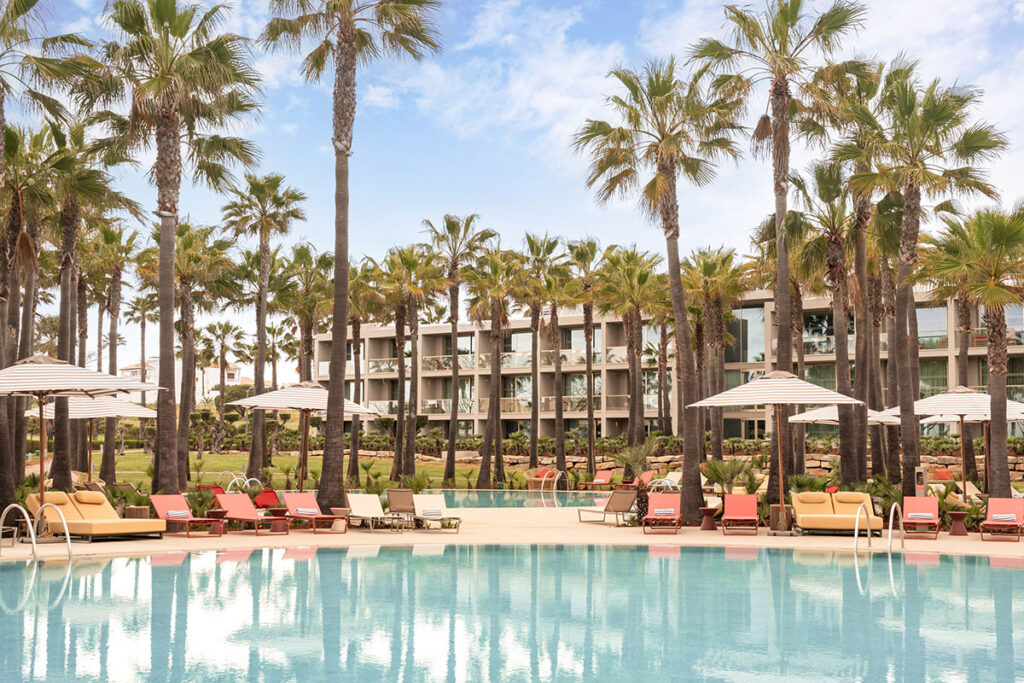 Palm-lined pool at the Kimpton Atlântico Algarve