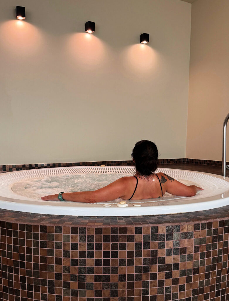 Woman relaxing in the jacuzzi at the Kimpton Atlântico Algarve Wellness Hub