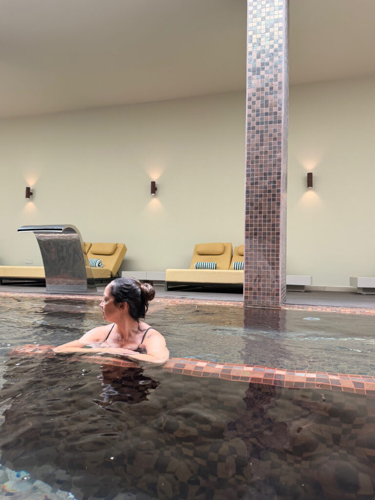 Woman swimming in the heated indoor pool at the Kimpton Atlântico Algarve Wellness Hub