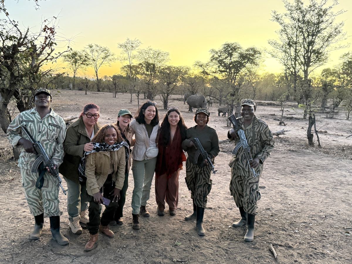 The group with armed rangers in camouflage before a rhino walk at sunset
