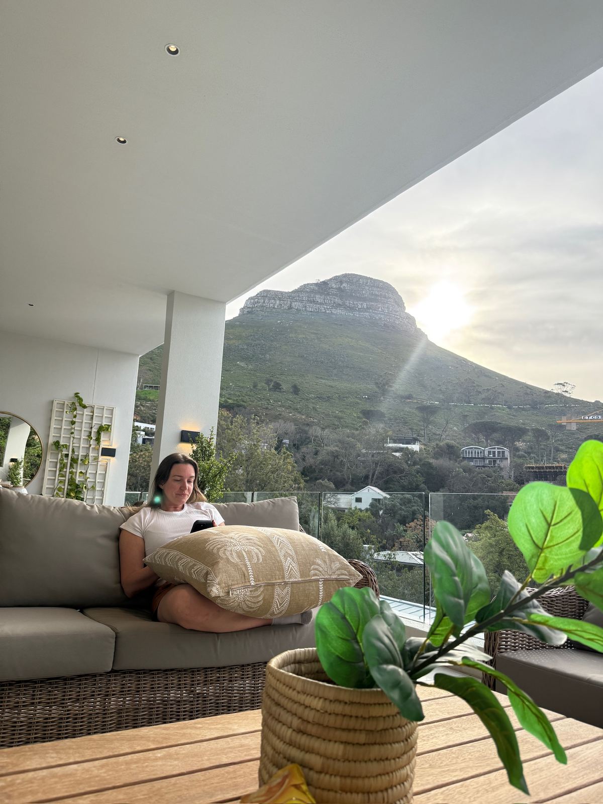 A woman relaxing on the Camps Bay villa terrace with Lion's Head behind her
