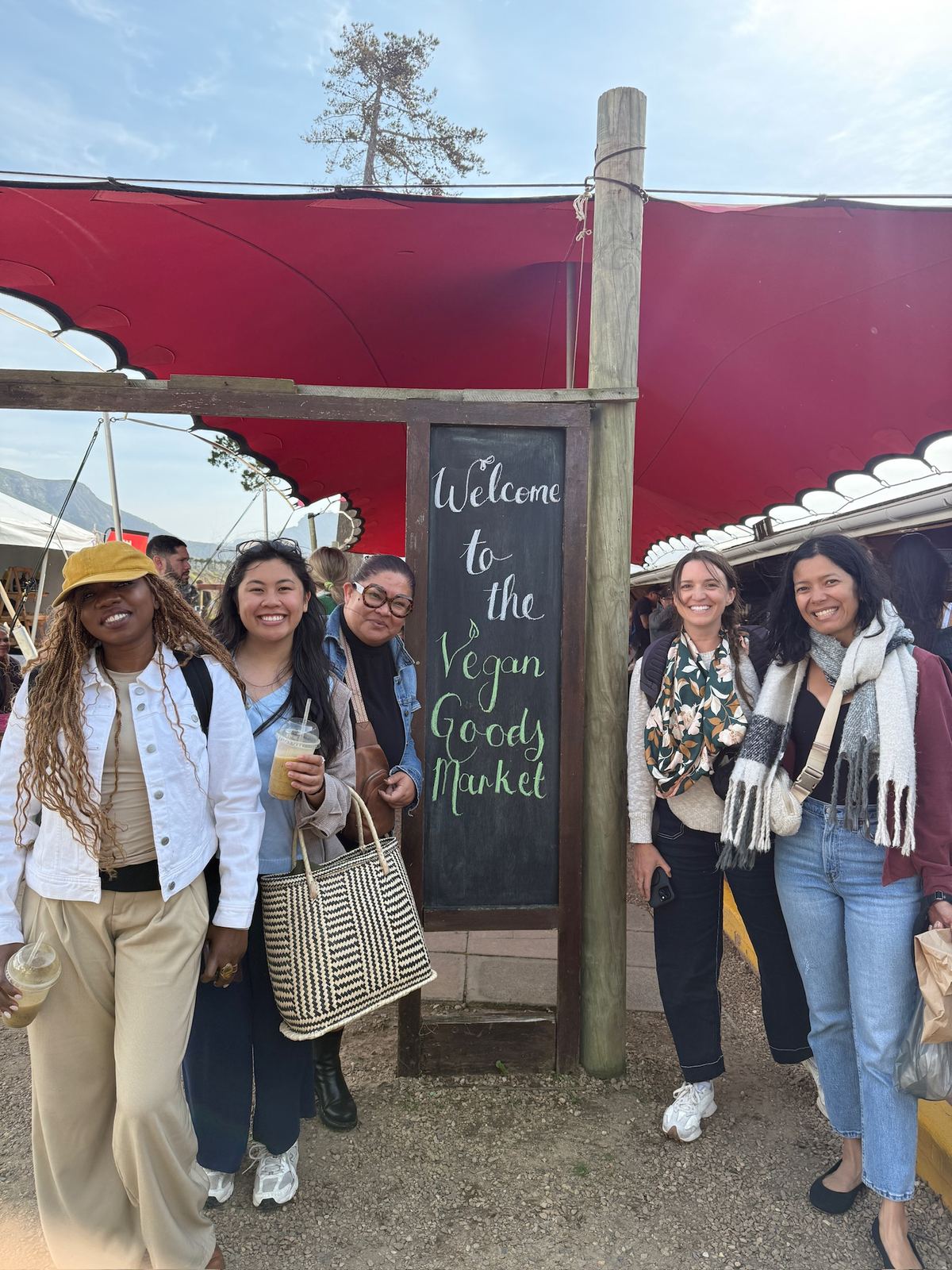 The group standing by the welcome sign at the Vegan Goods Market
