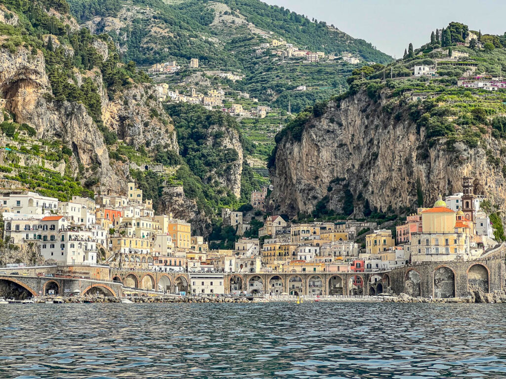 The towns of Atrani and Amalfi seen from the boat, tucked under tall cliffs.