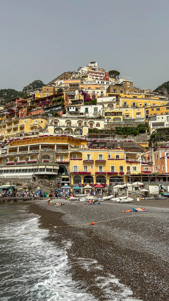 The dark sand beach at Positano with the town rising behind it.