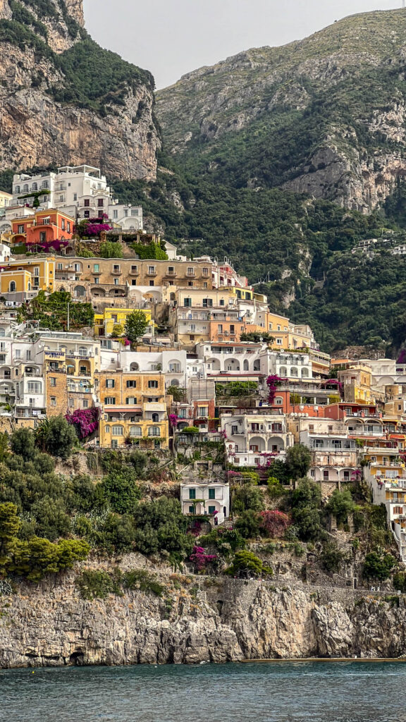 Pastel houses stacked up the cliff in Positano, seen from the ferry.