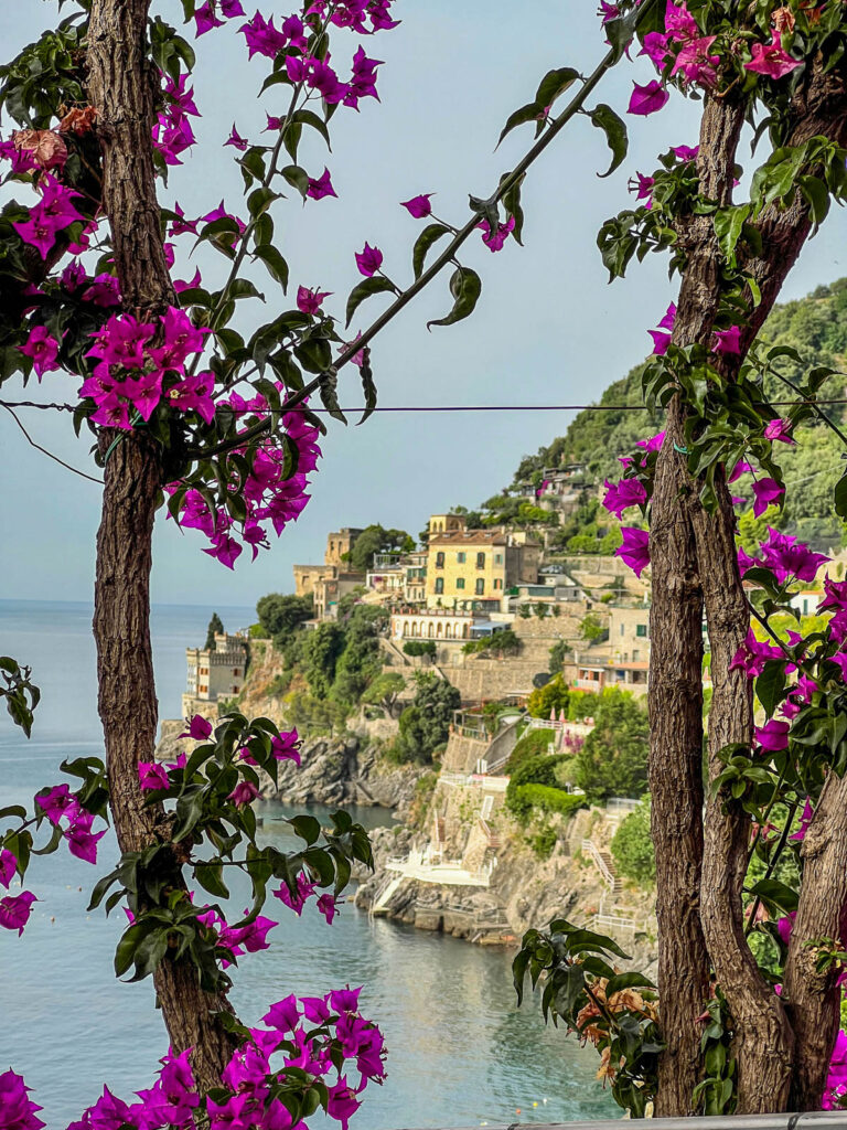 The Amalfi Coast framed by bougainvillea branches and flowers at Hotel Marmorata.