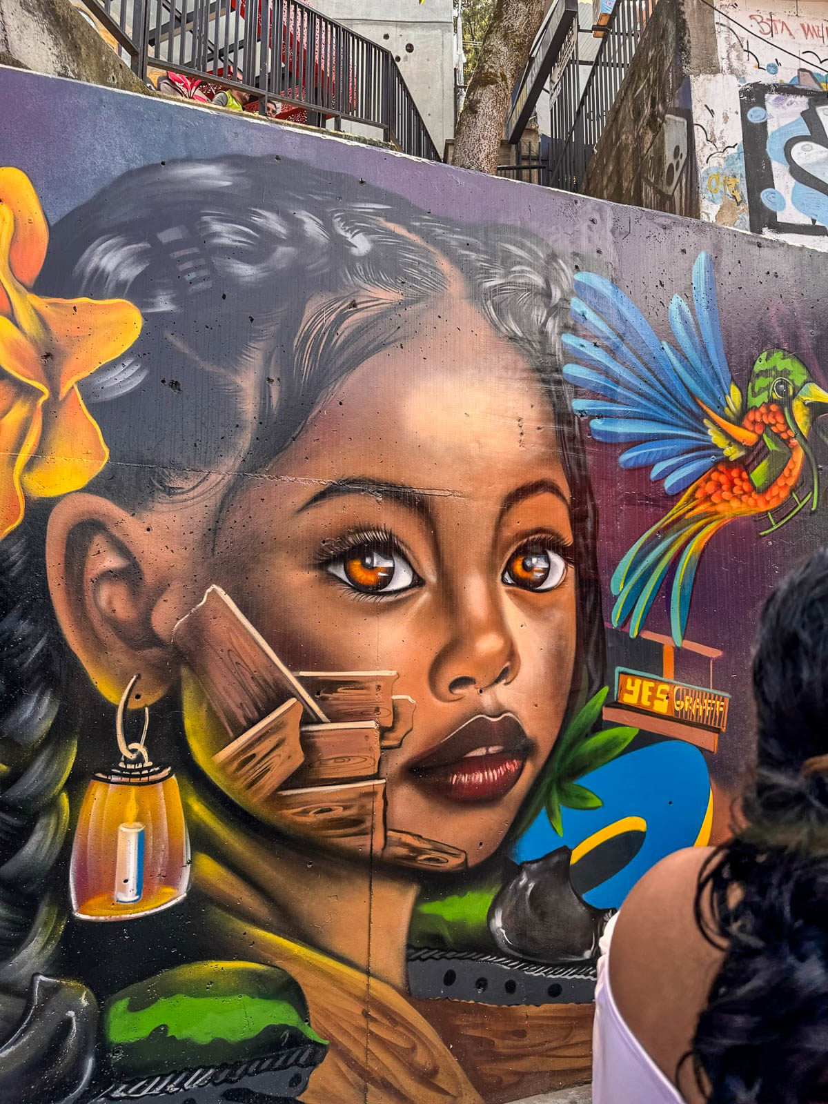 Street art portrait of a woman with a hummingbird in Comuna 13