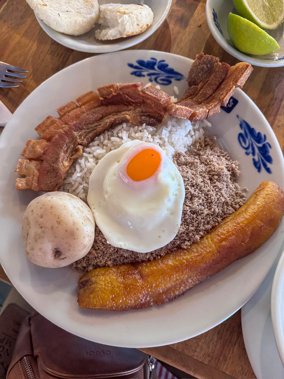 Bandeja paisa with rice, beans, a fried egg, chicharrón, plantain, and an arepa