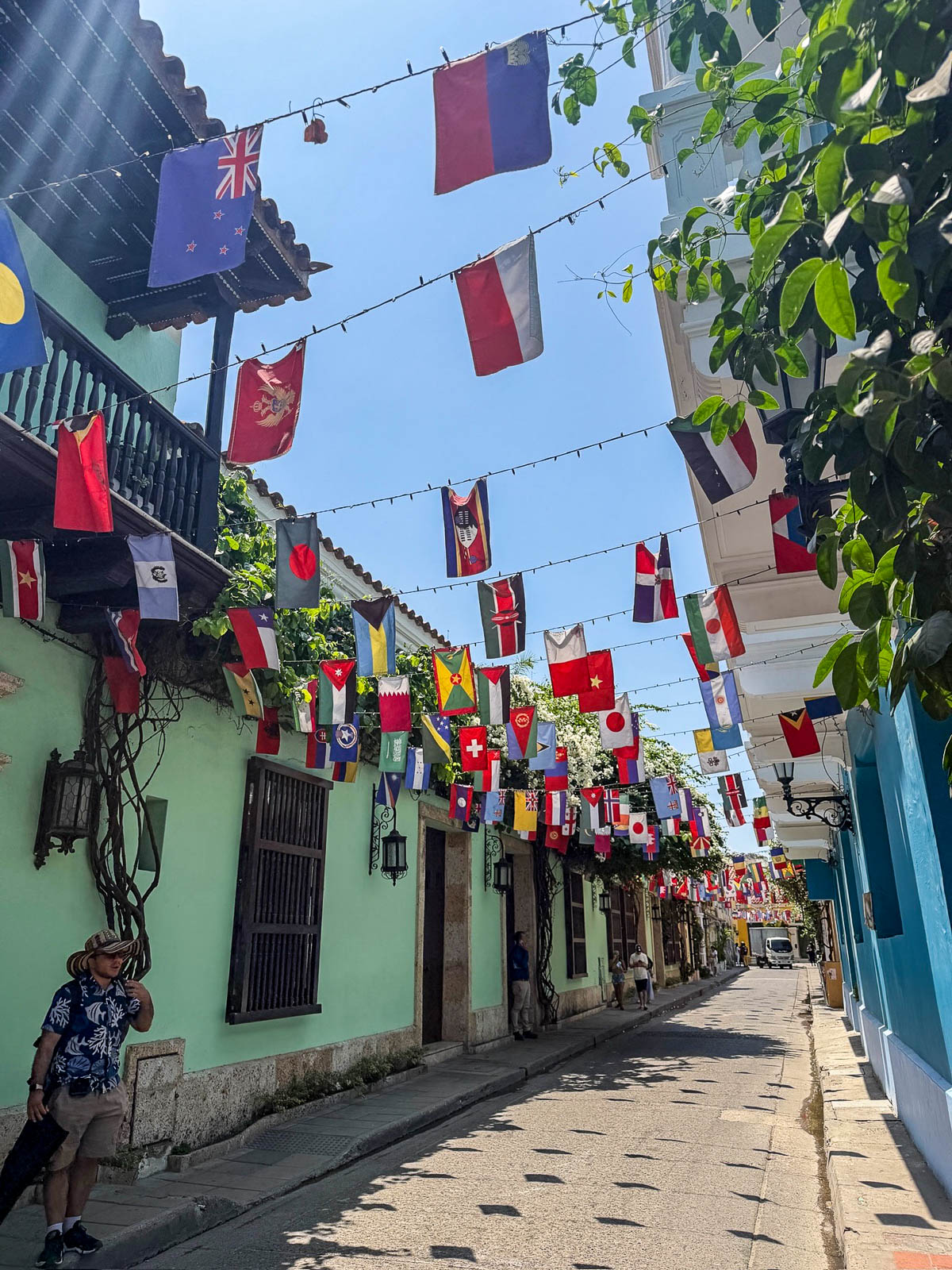 Strings of colorful flags hanging over a Getsemaní street lined with pastel houses