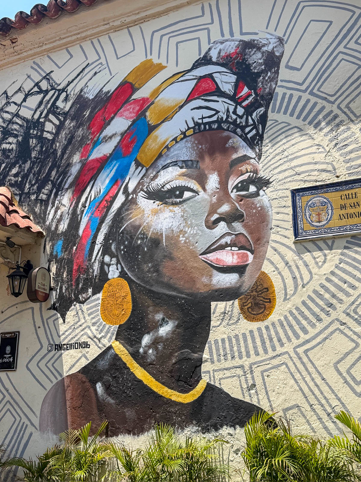 Mural of a woman in a colorful head wrap on a wall in Getsemaní