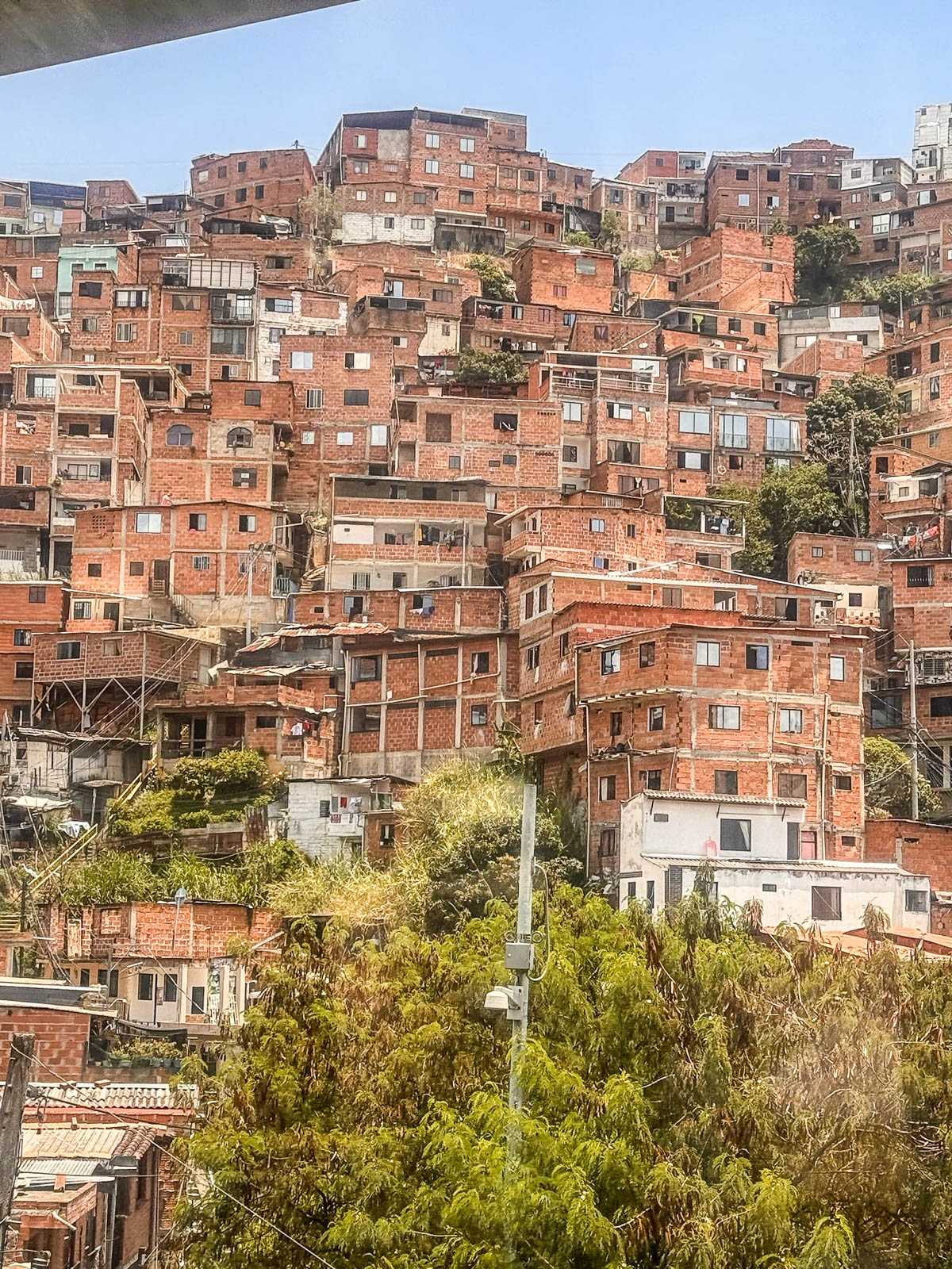 Red brick homes stacked up a hillside in Medellín