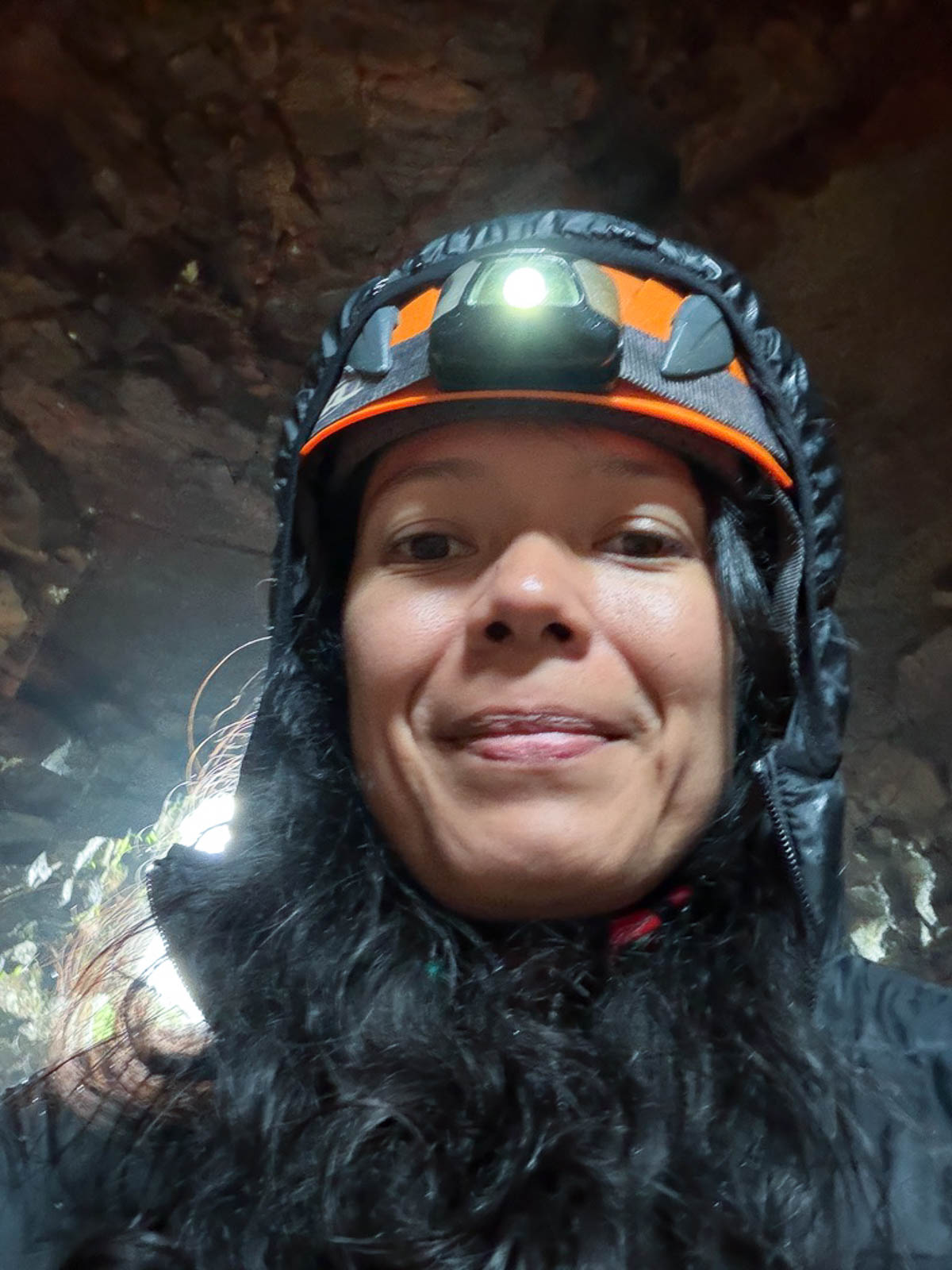 Toni wearing a helmet and headlamp inside Raufarhólshellir lava tunnel