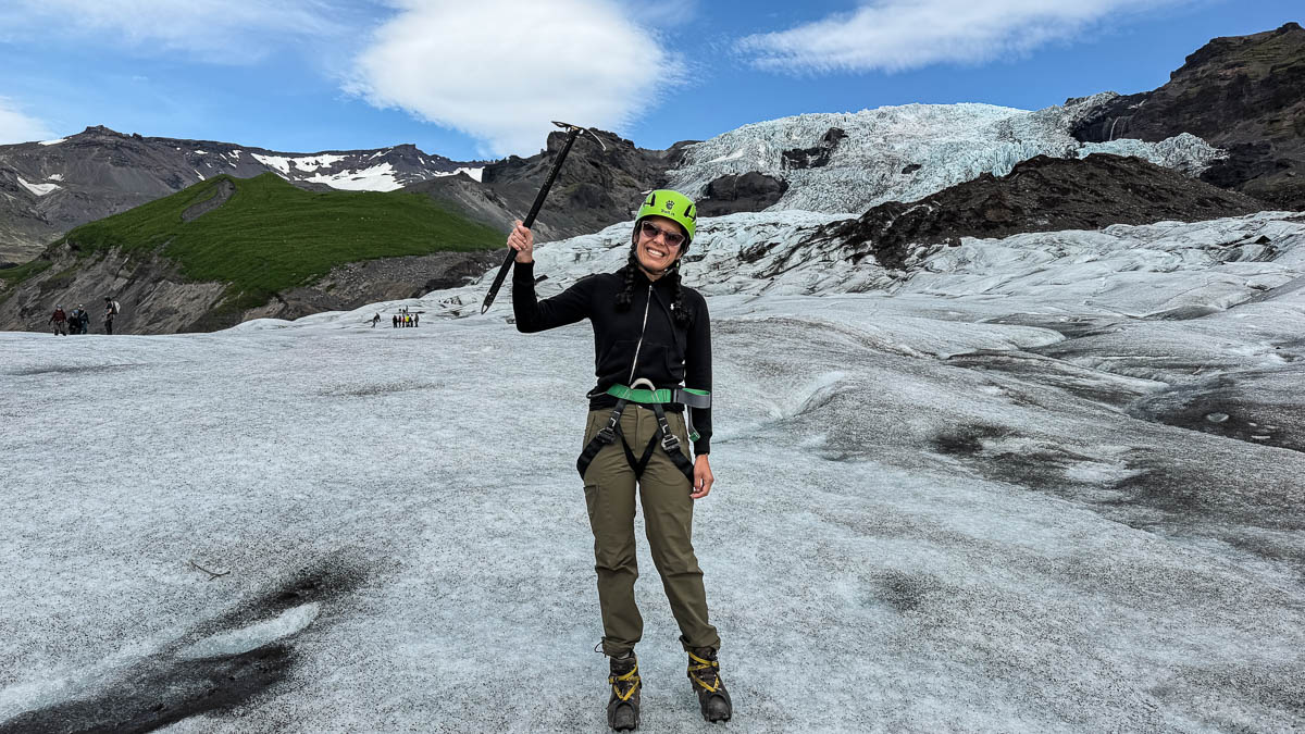 Toni standing on Sólheimajökull glacier in Iceland holding an ice axe