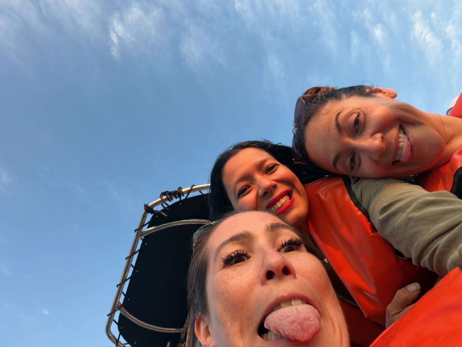 Three friends in life jackets taking a selfie on a boat trip to the Benagil Caves