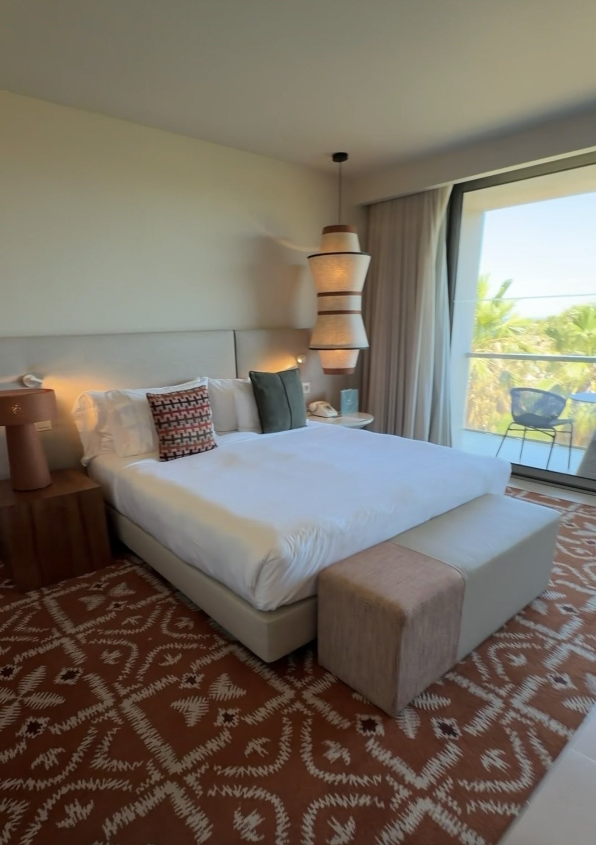 Bed and balcony door in our ocean-view room at Kimpton Atlântico Algarve