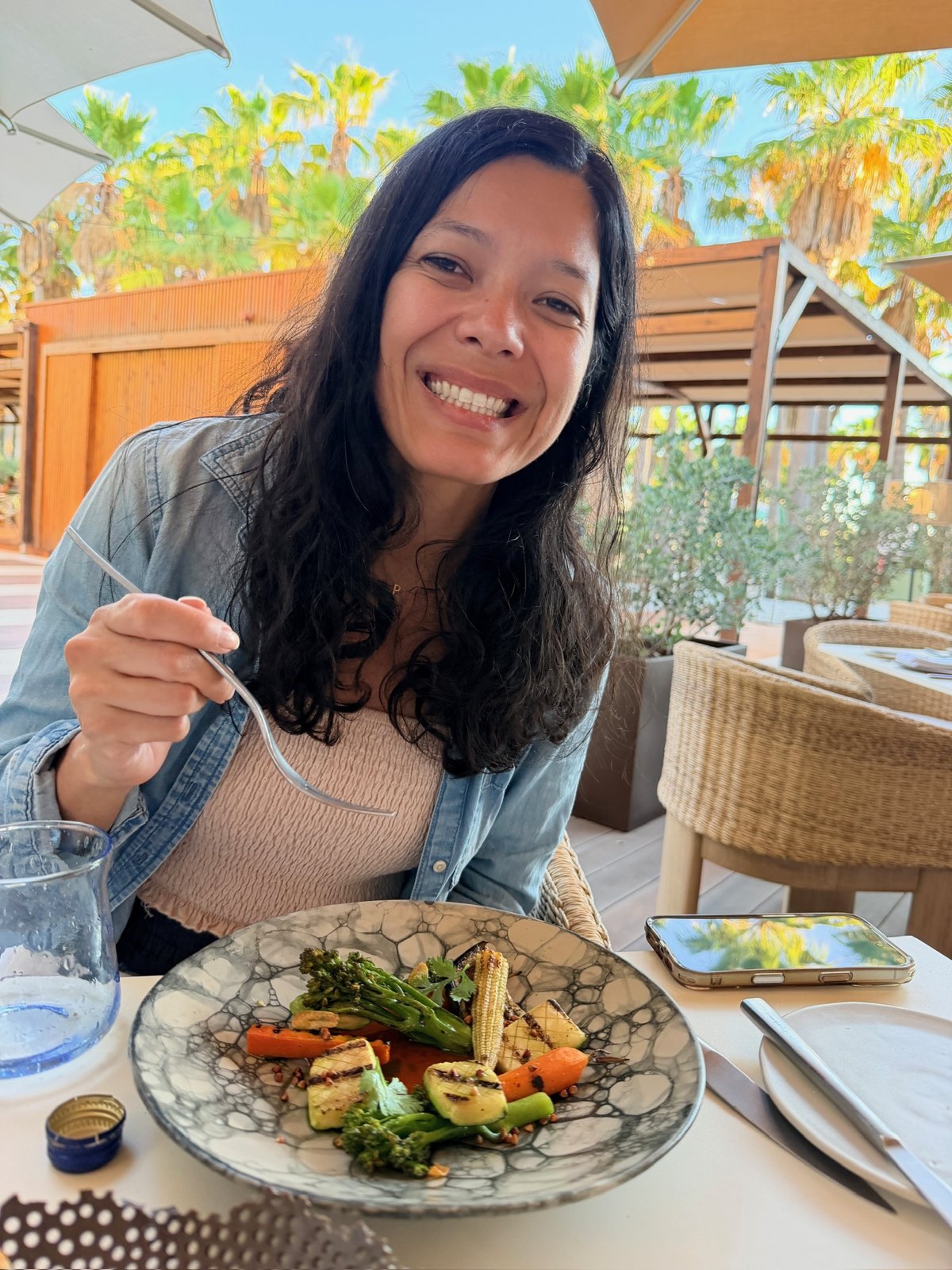 Toni smiling with a plate of grilled vegetables at dinner at Sombra, Kimpton Atlântico Algarve