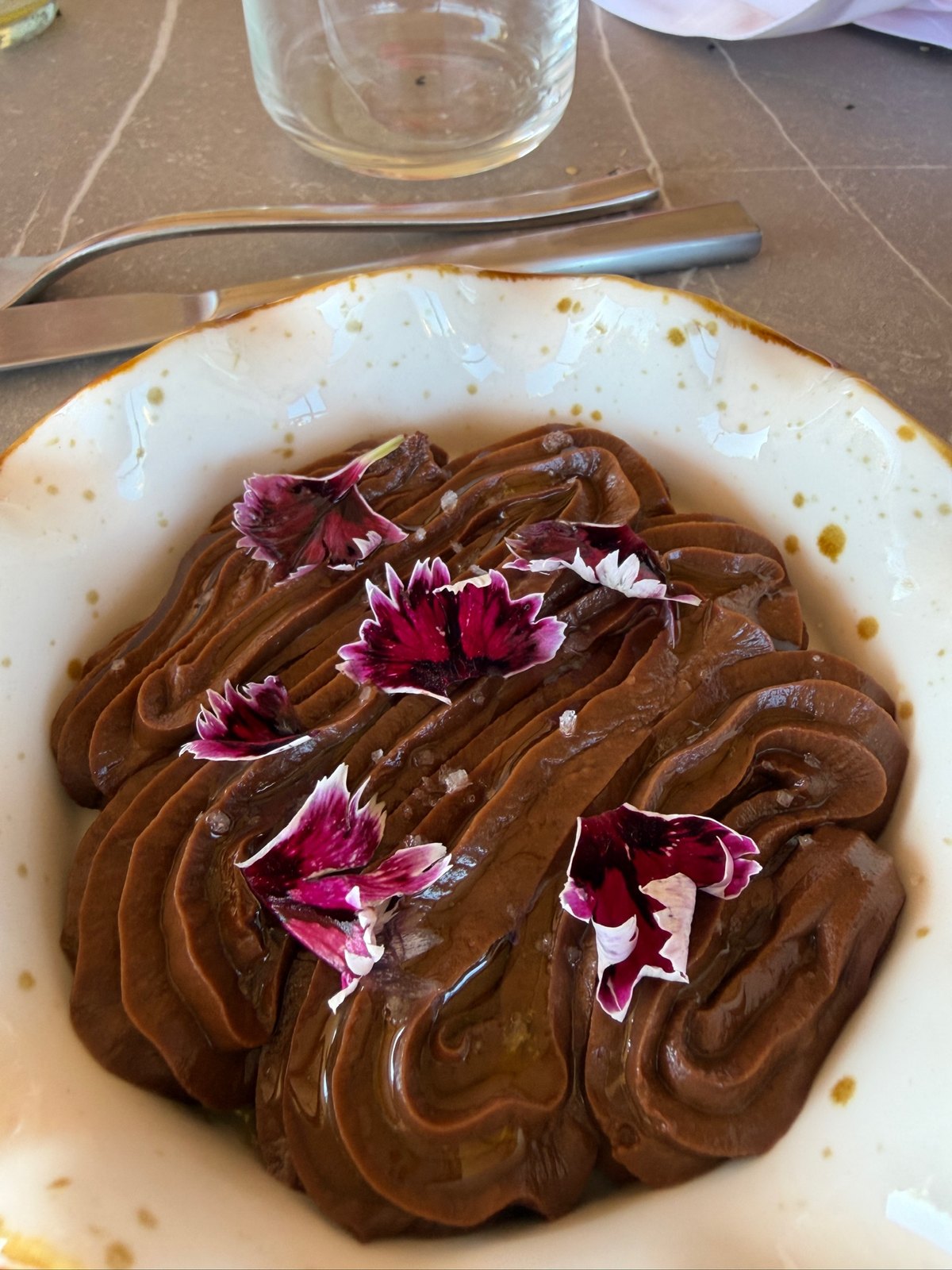 Vegan chocolate dessert topped with edible flowers at Zénite Rooftop