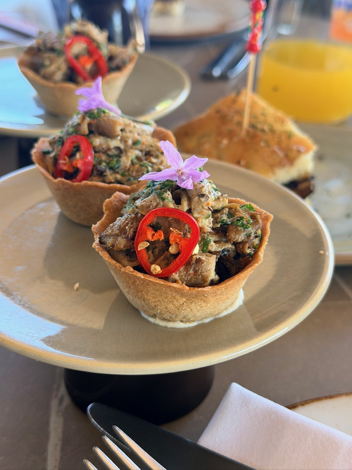 Mushroom cups topped with chili and edible flowers at Zénite Rooftop