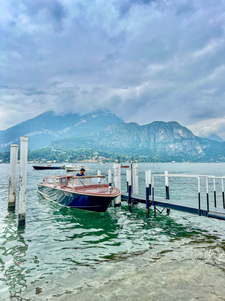 Wooden boats moored at the Bellagio waterfront with mountains across Lake Como.