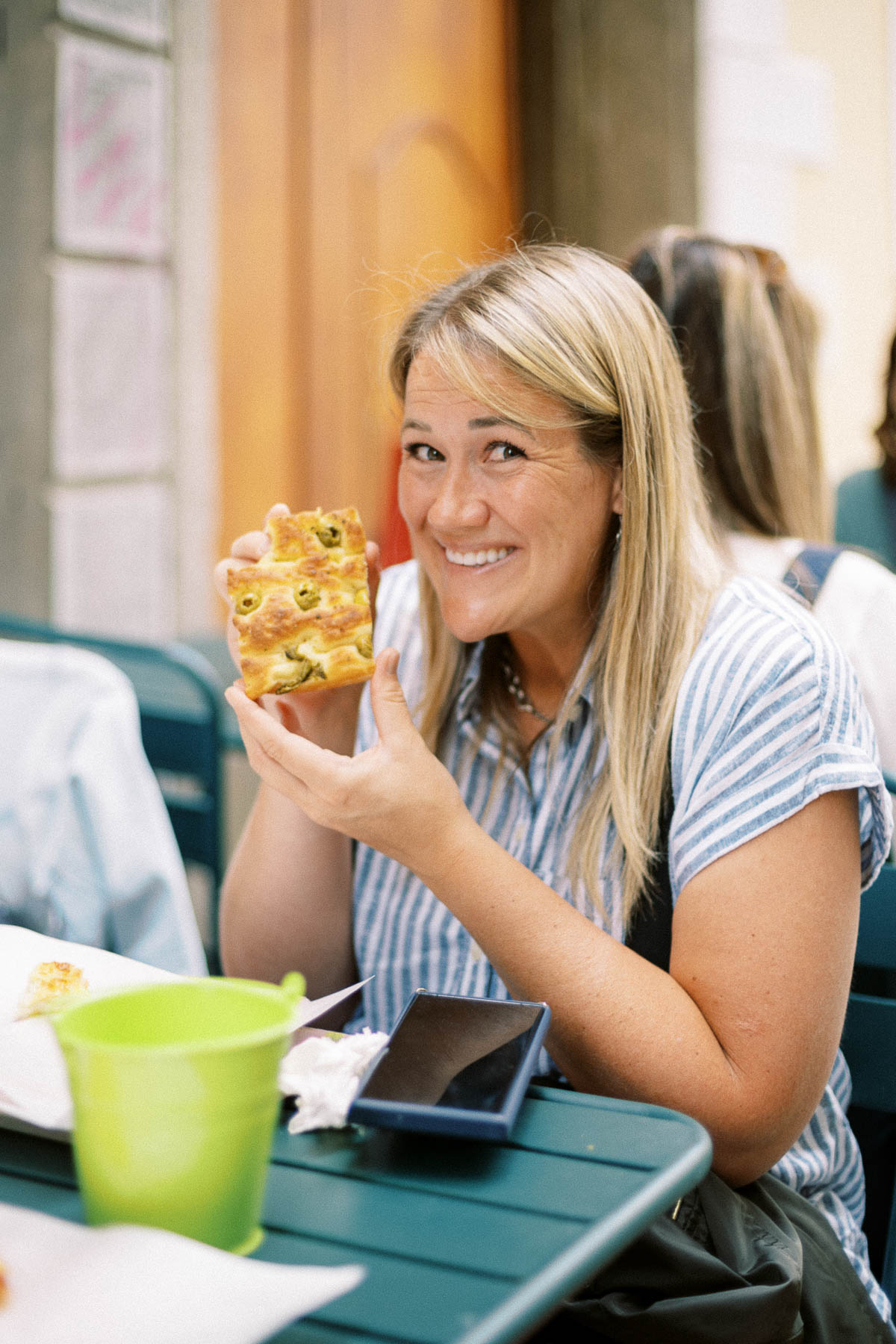 A traveler smiling and holding a slice of focaccia on the Milan food tour