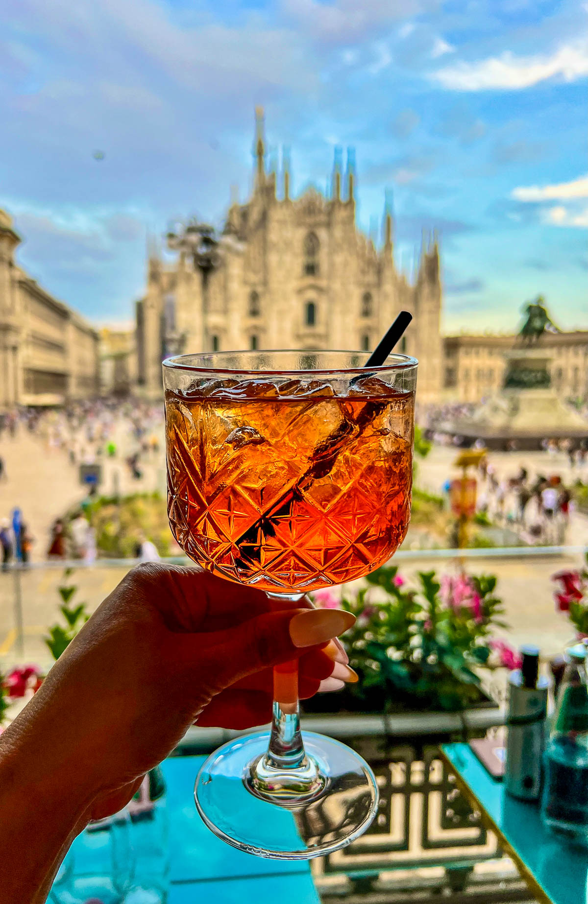 An Aperol spritz on the terrace at Terrazza Aperol with the Duomo spires behind it