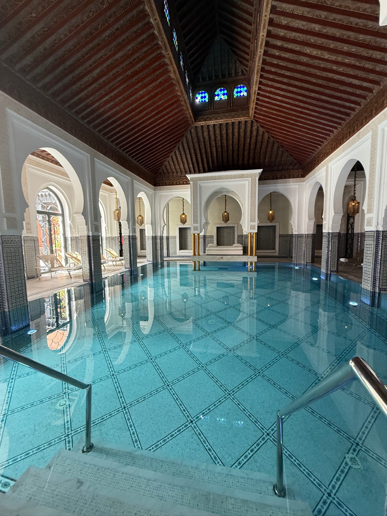 Turquoise indoor pool under a carved wooden ceiling at the La Mamounia spa