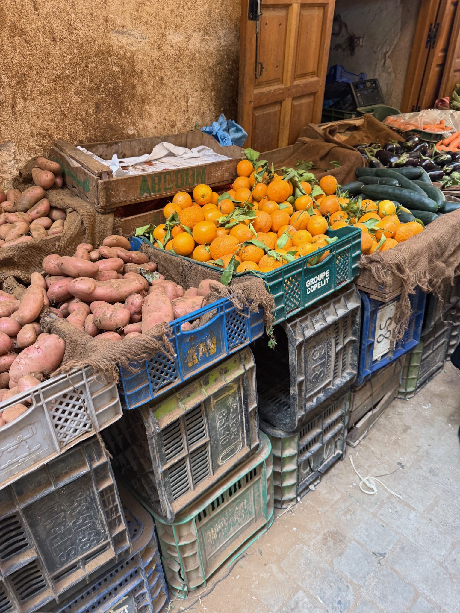 Crates of oranges and sweet potatoes at a produce stall in the Fes medina
