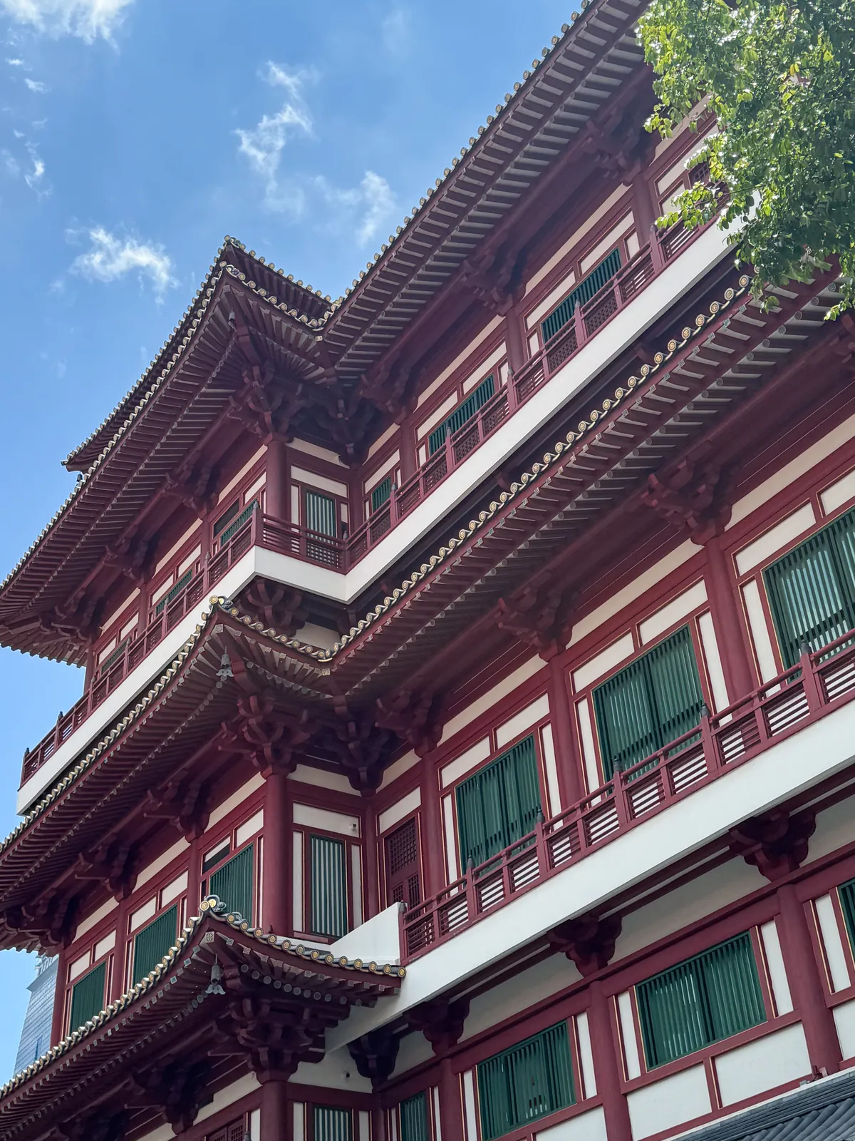 Red and white tiered roofs of the Buddha Tooth Relic Temple in Chinatown against a blue sky