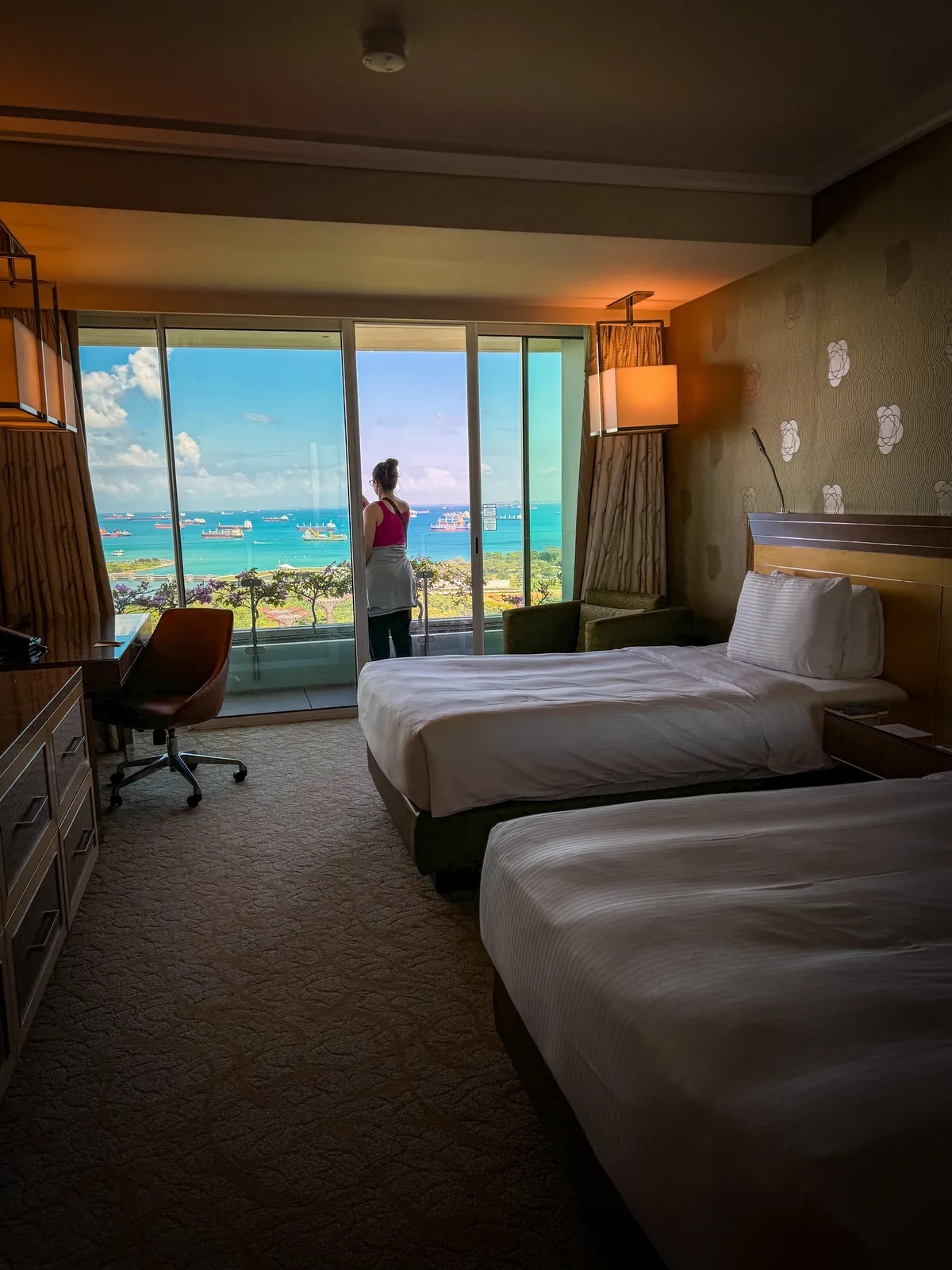 Liz looking out the floor to ceiling windows of our Marina Bay Sands room over the sea
