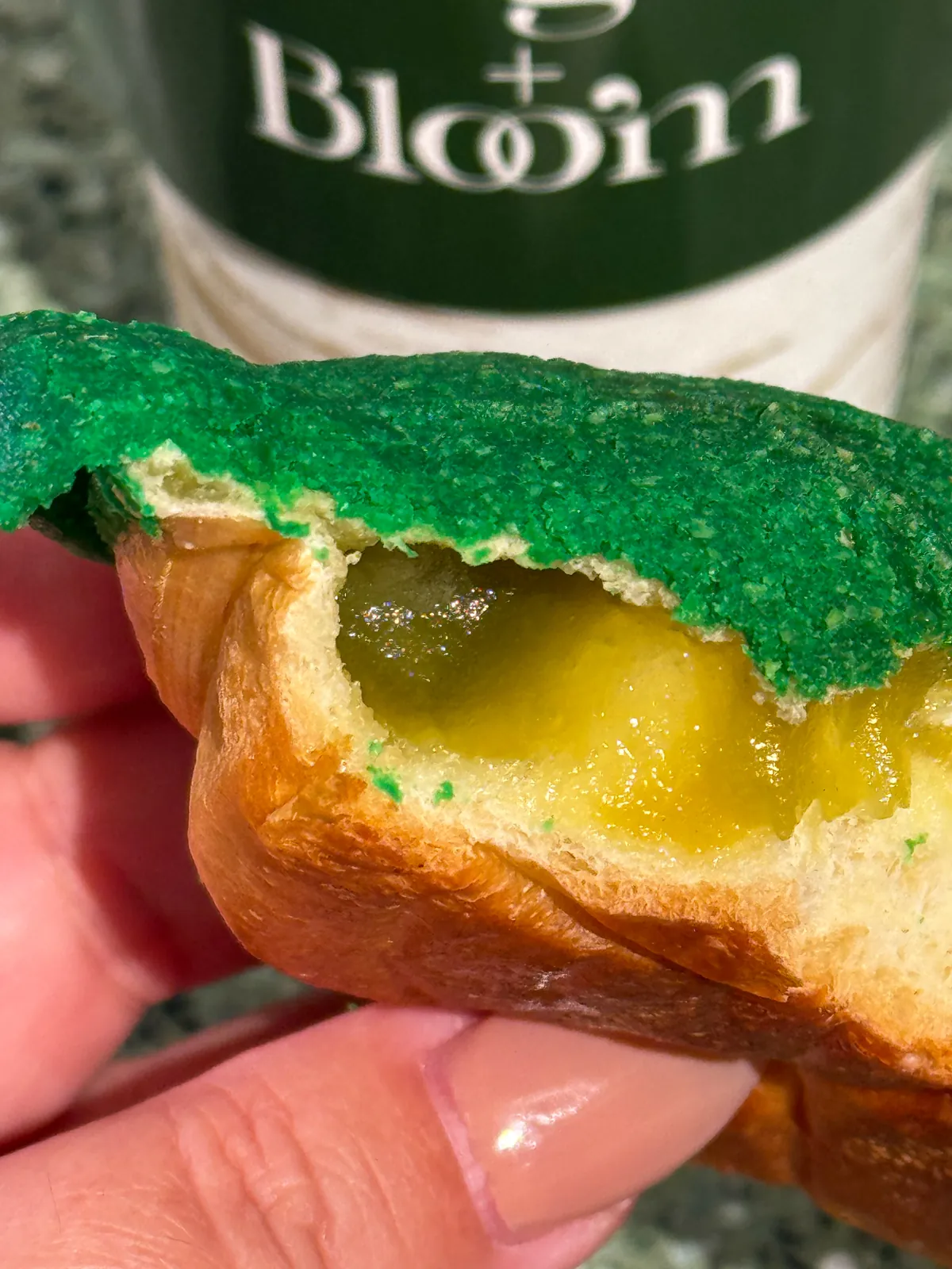 A pandan brioche bun from Origin + Bloom broken open to show its rich golden pandan filling